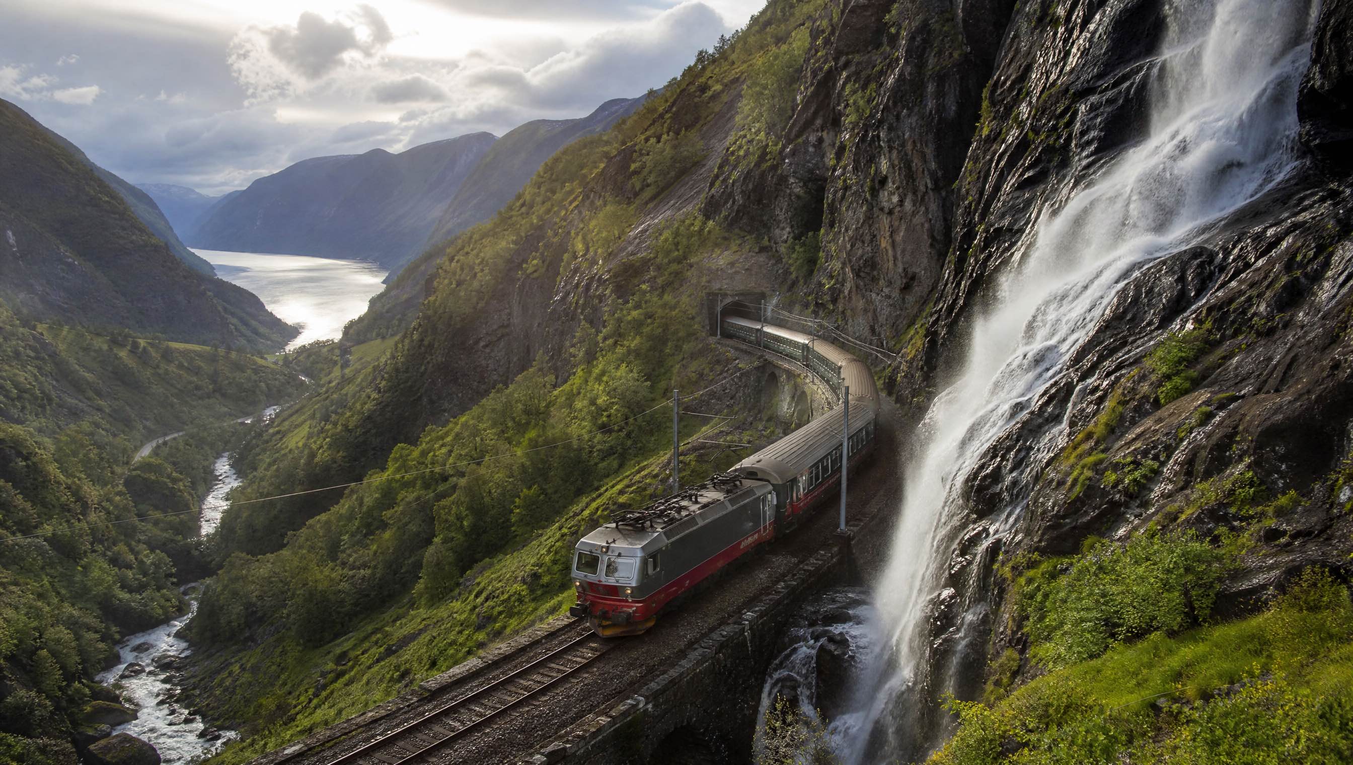 Flåm Railway descending beside waterfalls in Norway