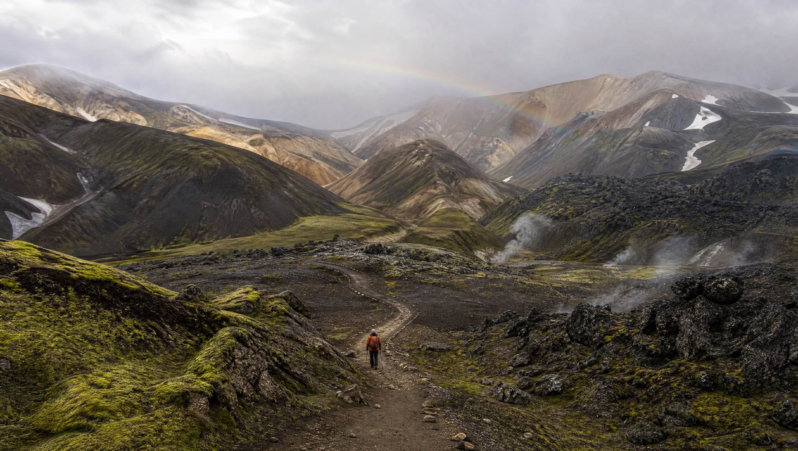 A hiker following the Laugavegur trail through Icelandic lava and rhyolite mountains